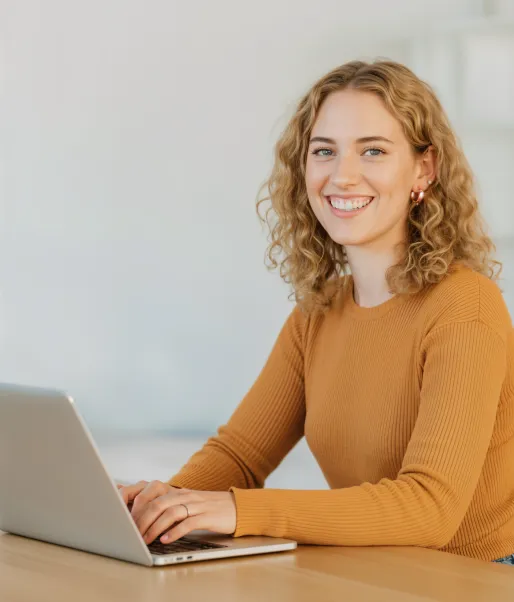 Smiling client sitting at her desk with a laptop